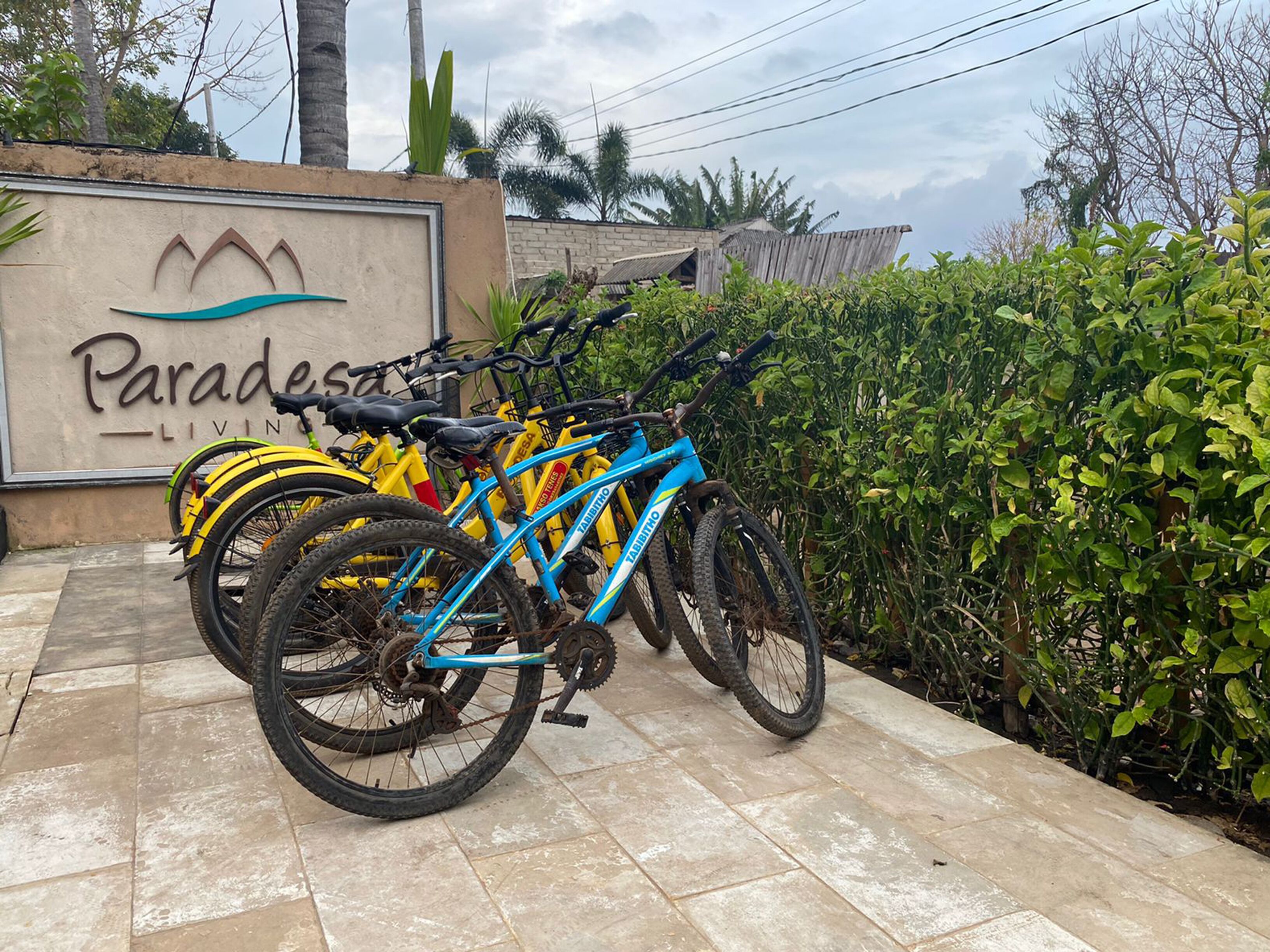 A sign for 'Paradesa Living' with bicycles parked in front.