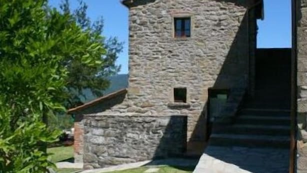A stone building with a small window and a door, surrounded by a grassy area with stepping stones leading to a staircase. - Stunning private villa with private pool, WIFI, TV, pets allowed and parking, close to Cortona (Cortona)
