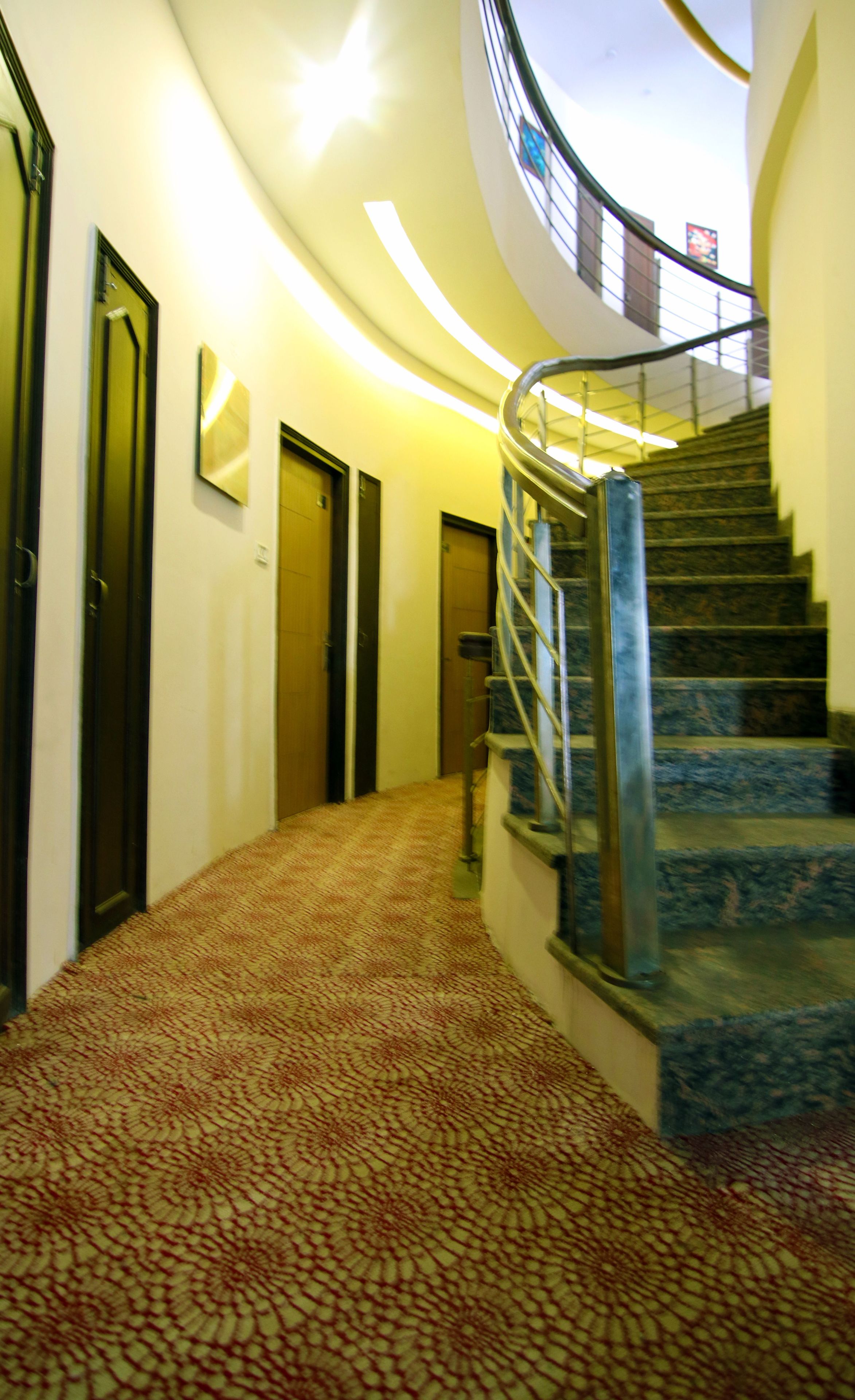 A curved staircase with a metal railing leading to a higher floor.