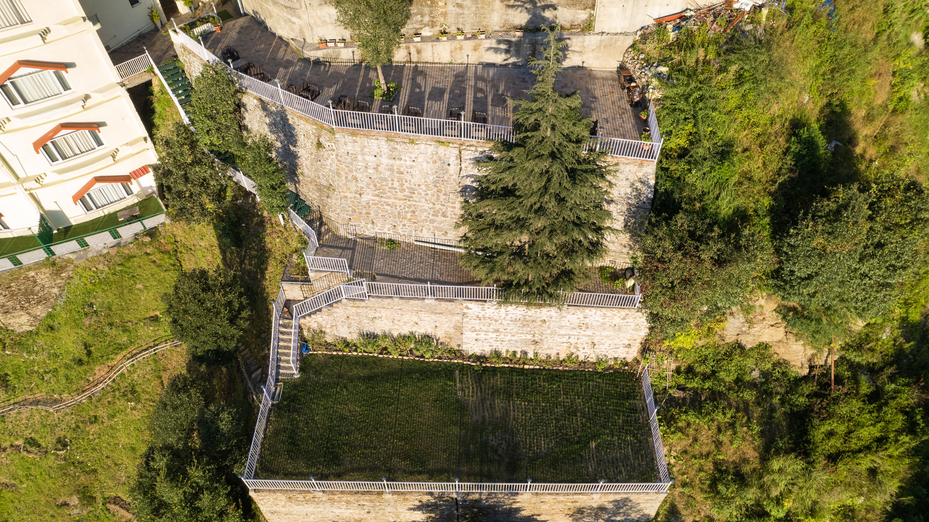 A stone retaining wall with a paved area and a staircase.