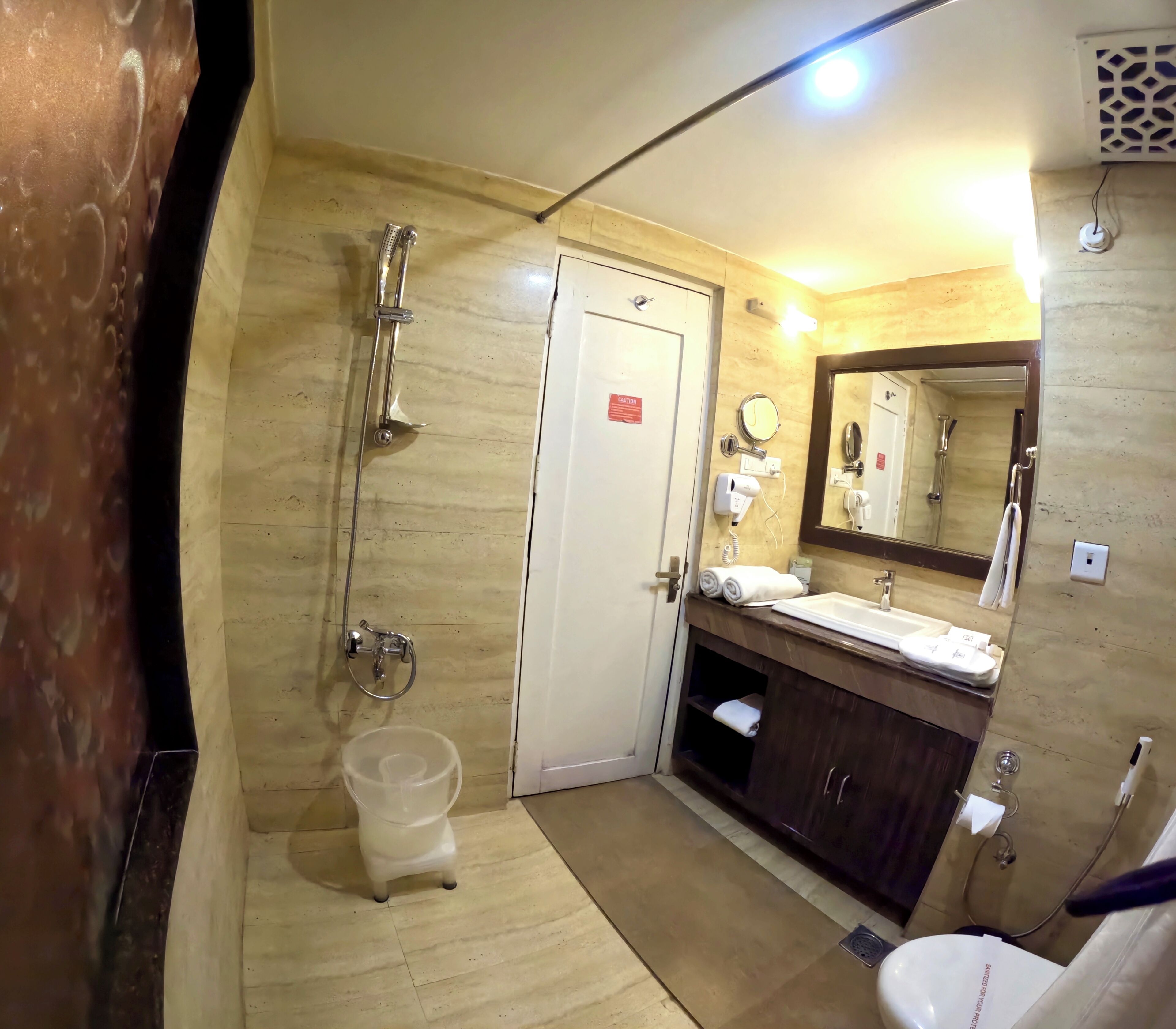 Ein Badezimmer mit Dusche, Waschbecken, Spiegel und Toilette.