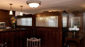Ein traditioneller Essbereich mit Holztisch und -stühlen, einem eingebauten Herd und einer Deckenleuchte.