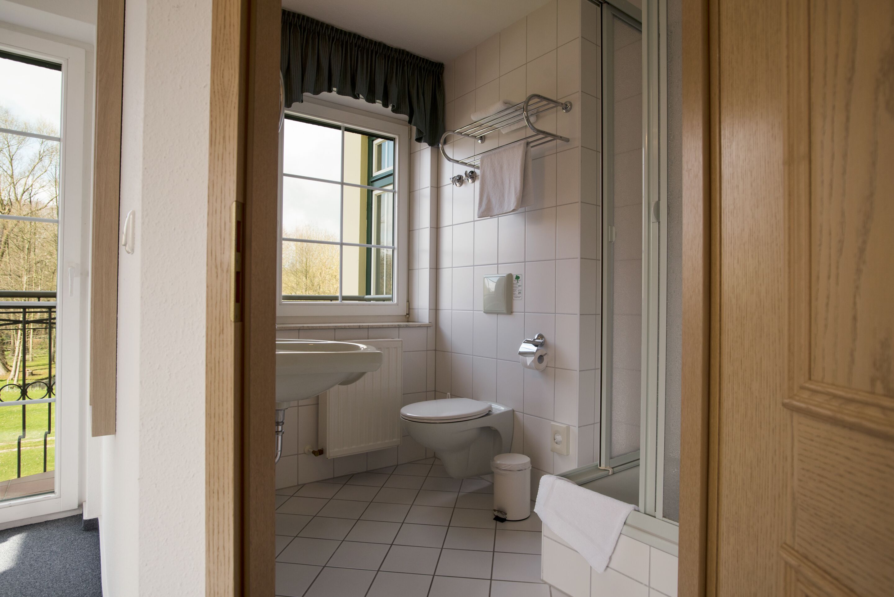 A bathroom with a toilet, sink, and shower.