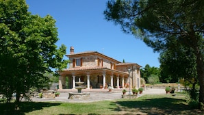 A stone building with a tiled roof, columns, and a fountain in the courtyard. - Stunning private villa for 8 guests with private pool, WIFI, TV, terrace, pets allowed and parking (Lucignano)