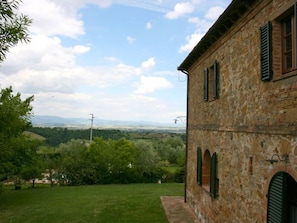 Situated in a lush landscape, this traditional building offers a view of rolling hills and distant mountains.