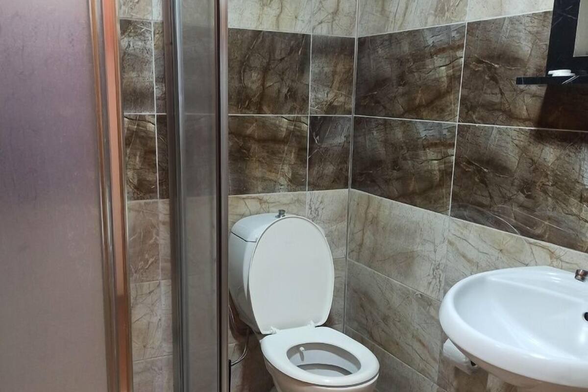 Un baño con inodoro, lavamanos y ducha.