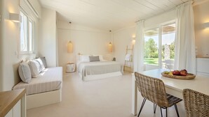 A bedroom with a bed, bedside table, and a window with curtains. - Ta Spitakia (Kos)