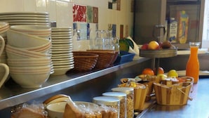 Una encimera de cocina con diversos alimentos, como pan, bollería y un frutero.