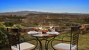 A table set for a meal with a view of a mountainous landscape.