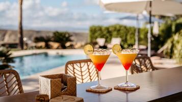 Dos cócteles sobre una mesa con vista a la piscina.