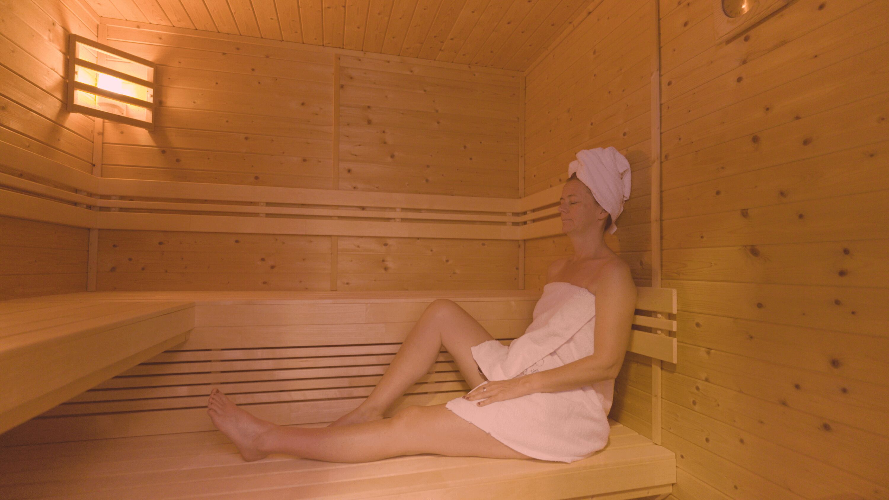 Una sauna con panche in legno e soffitto spiovente.