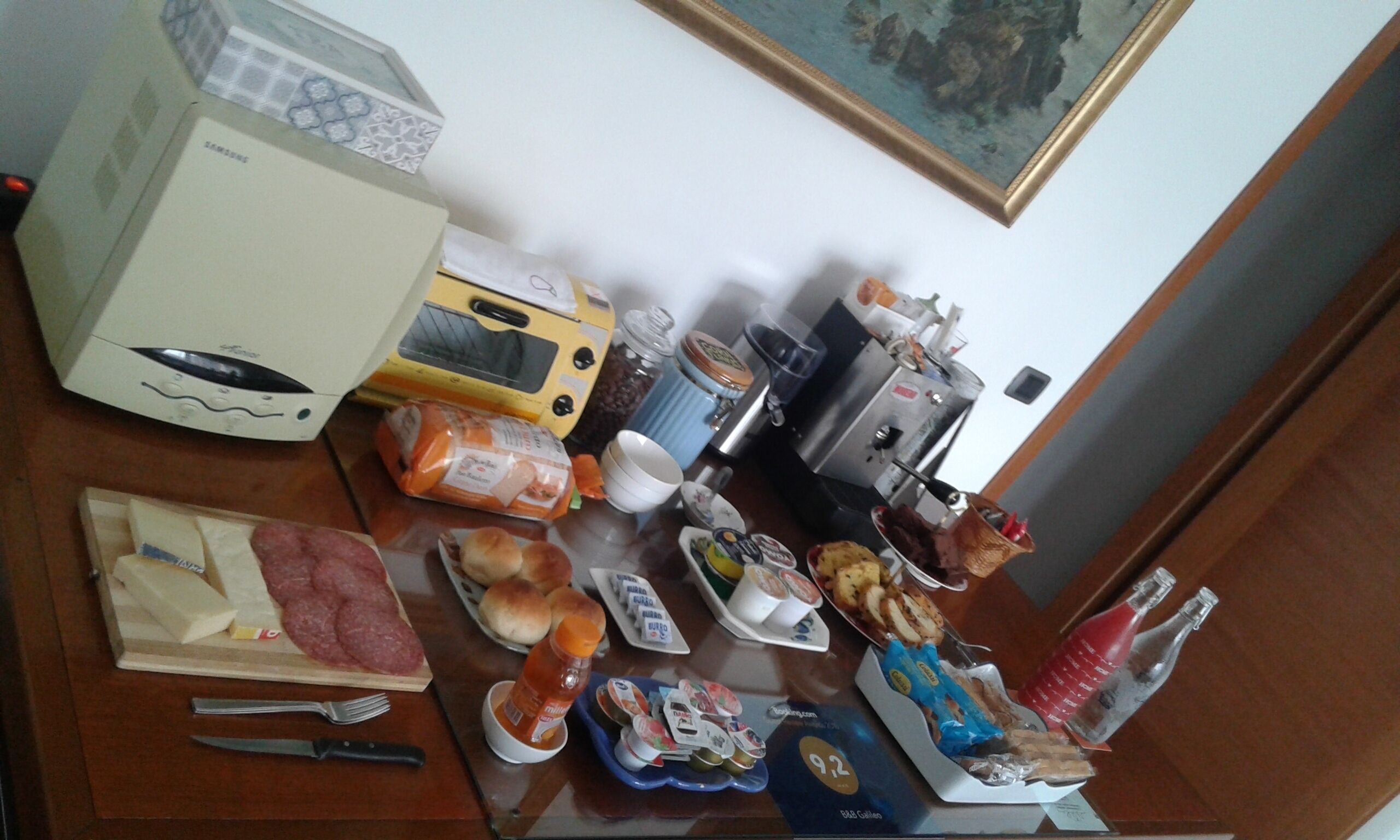 A dining table with various food items, a coffee maker, and a microwave.