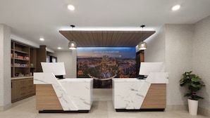 A reception area with marble reception desks, a cityscape poster, wooden shelving with toiletries, and pendant lighting.