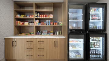 Uma cozinha com armários de madeira, bancada e dois refrigeradores.
