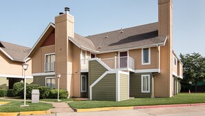A multi-story residential building with a balcony, a chimney, and a well-maintained lawn. - Extended Studio Suite Hotel (Bossier City)