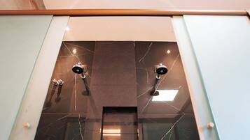 Casa de banho moderna com painel de mármore e dois chuveiros.