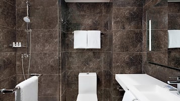 Ein modernes Badezimmer mit Dusche, Toilette und Waschbecken, alles mit Chromarmaturen.