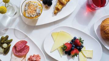 A table with various food items including cheese, fruits, and pastries.