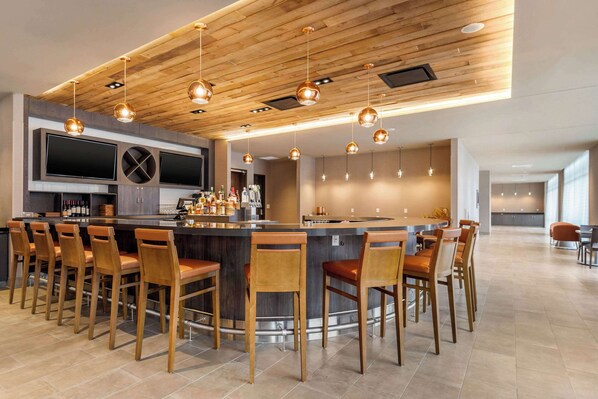 A modern kitchen with a central island, bar seating, and pendant lighting.