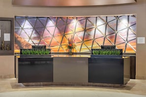 Un comptoir d’accueil doté d’un décor mural géométrique et offrant une vue sur le coucher de soleil.