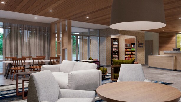 A modern interior with a seating area, a round wooden table, and a large pendant light. - Fairfield Inn & Suites Athens Marriott (Athens)