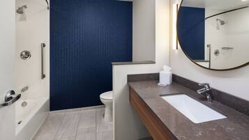 A modern bathroom with a bathtub, toilet, and sink.
