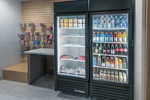 Un expositor refrigerado con diversas bebidas y aperitivos.
