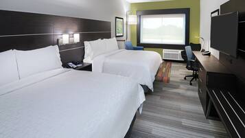Habitación de hotel con dos camas, un escritorio, una silla, un televisor y una ventana.