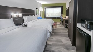 Habitació d'hotel amb dos llits, una taula de treball, una cadira, microones i nevera.