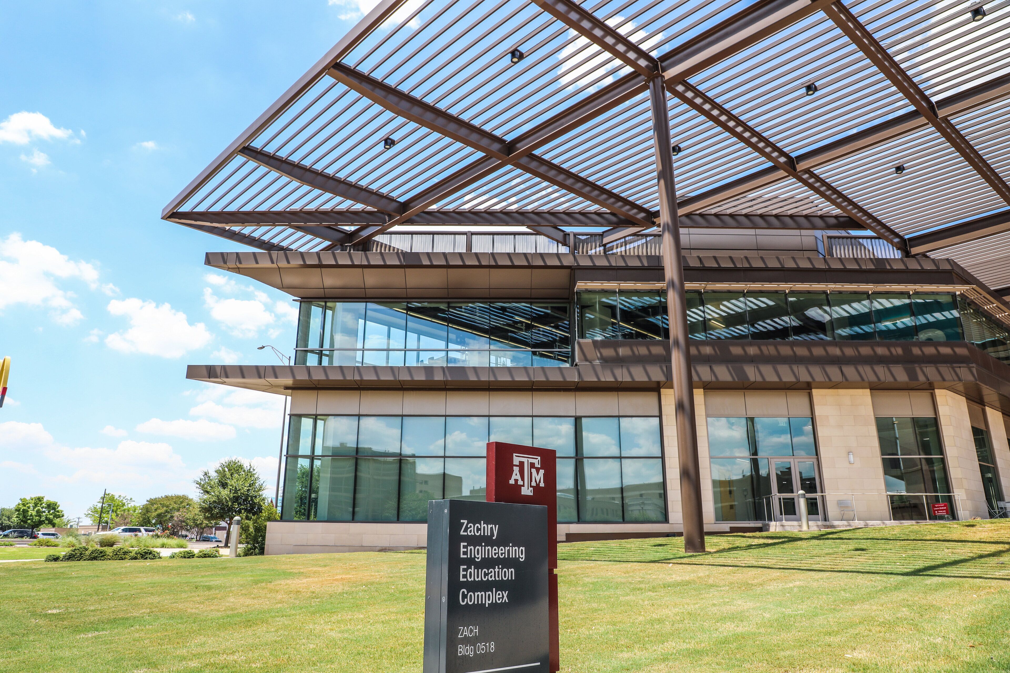 The exterior of the Zachry Engineering Education Complex with a modern design, large glass windows, and a clear sky.