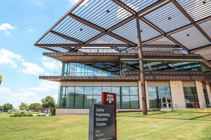 The exterior of the Zachry Engineering Education Complex with a modern design, large glass windows, and a clear sky.