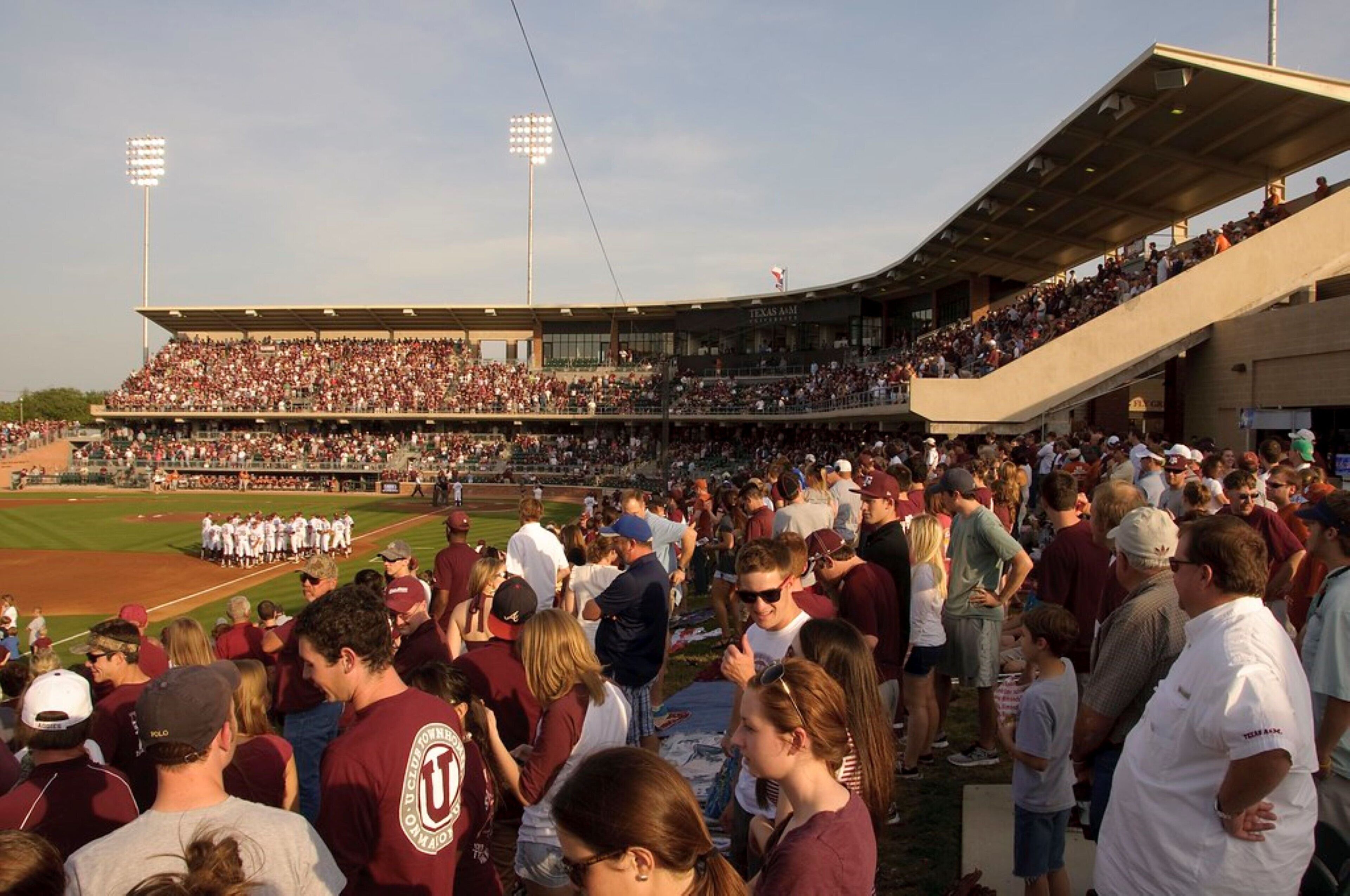 A stadium filled with spectators, featuring tiered seating and a large field.