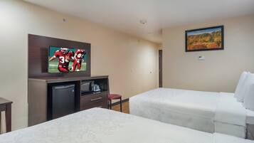 A hotel room with two beds, a TV, a small desk, and a painting on the wall.