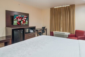 A hotel room with a bed, a desk, a television, a refrigerator, and a chair. - Red Roof Inn PLUS+ Fort Worth - Burleson (Burleson)