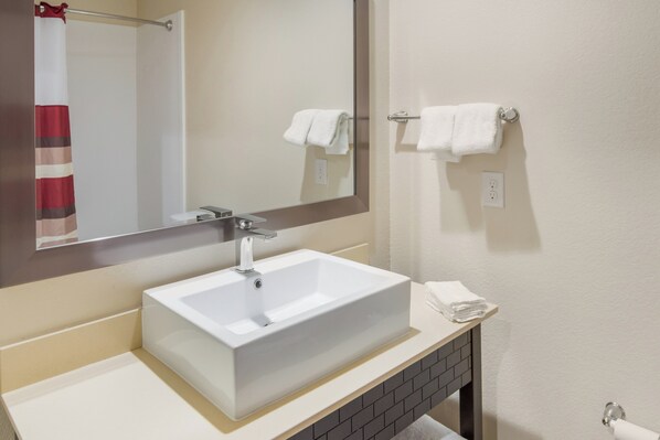 A bathroom with a white sink, a mirror, and a towel rack. - Red Roof Inn PLUS+ Fort Worth - Burleson (Burleson)