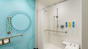 A bathroom with a shower, grab bars, and a white sink.