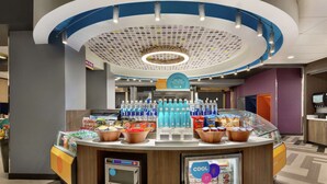 A self-service beverage station with a refrigerated display and a microwave. - Tru by Hilton St. Charles St. Louis, MO (St. Charles)