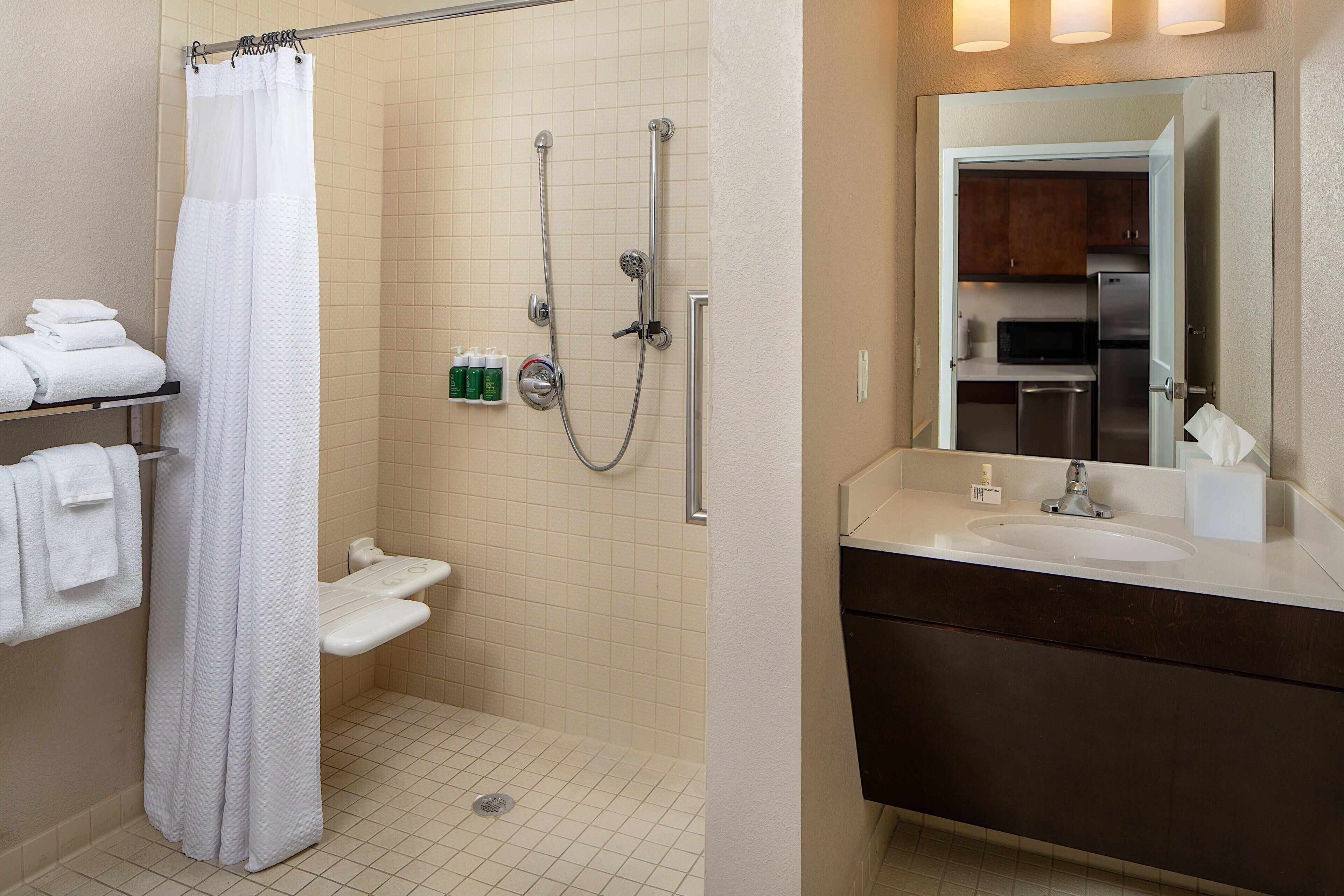 A bathroom with a shower, toilet, and sink.