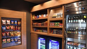Un espace proposant des distributeurs automatiques de collations et de boissons, avec un assortiment varié de produits.
