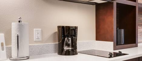 A kitchen with a built-in microwave, coffee maker, and dishwasher.