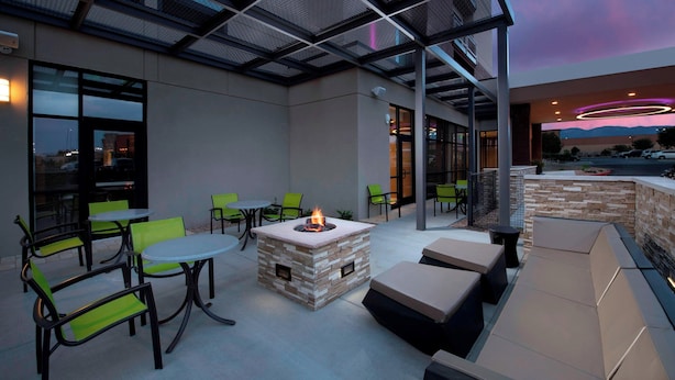 An outdoor patio area with a fire pit, seating, and a view of the cityscape. - SpringHill Suites by Marriott Albuquerque North/Journal Center (Albuquerque)
