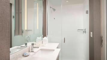 A modern bathroom with a glass-enclosed shower, a double sink vanity, and a large mirror.