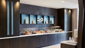 A modern kitchen with a built-in breakfast bar, wooden cabinets, and a decorative backsplash. - SpringHill Suites by Marriott Albuquerque North/Journal Center (Albuquerque)