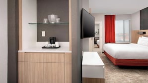 A modern hotel room with a wooden desk, a flat-screen TV, a bed with red bedding, and a large window with a view. - SpringHill Suites by Marriott Albuquerque North/Journal Center (Albuquerque)