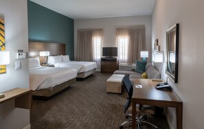 A hotel room with two beds, a desk, a chair, a TV, and a window with curtains. - Staybridge Suites Houston East - Baytown by IHG (Baytown)