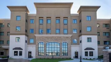 A multi-story hotel with a symmetrical facade, large windows, and a central entrance with a stone accent.
