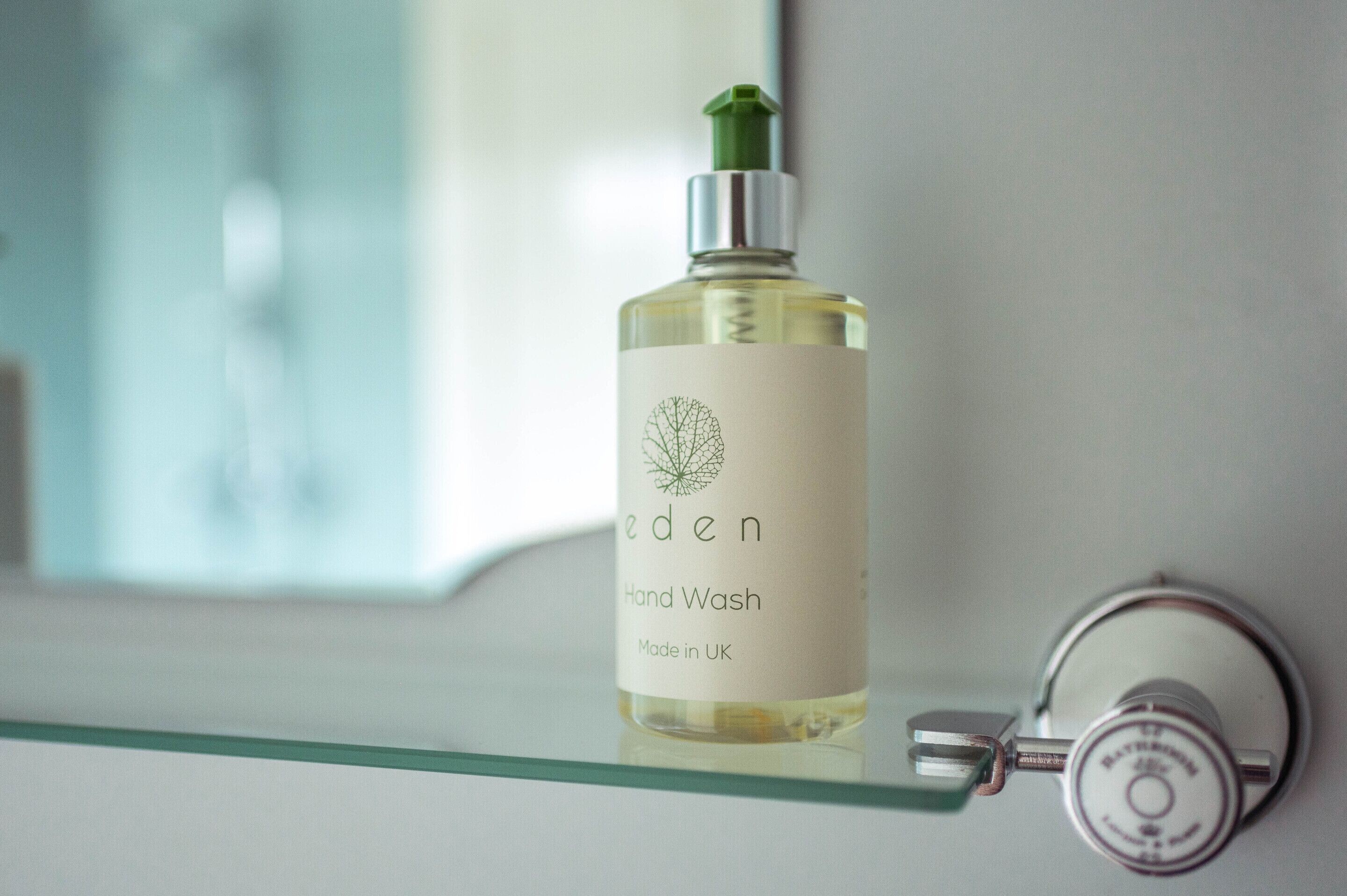 Een fles Eden Hand Wash op een glazen plank.