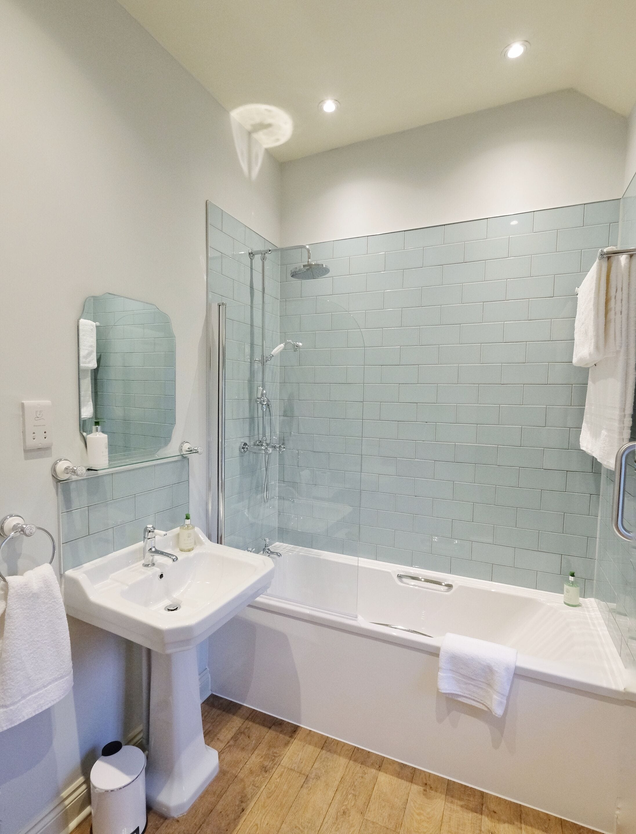 A bathroom with a glass-enclosed shower, a white sink, and a bathtub.