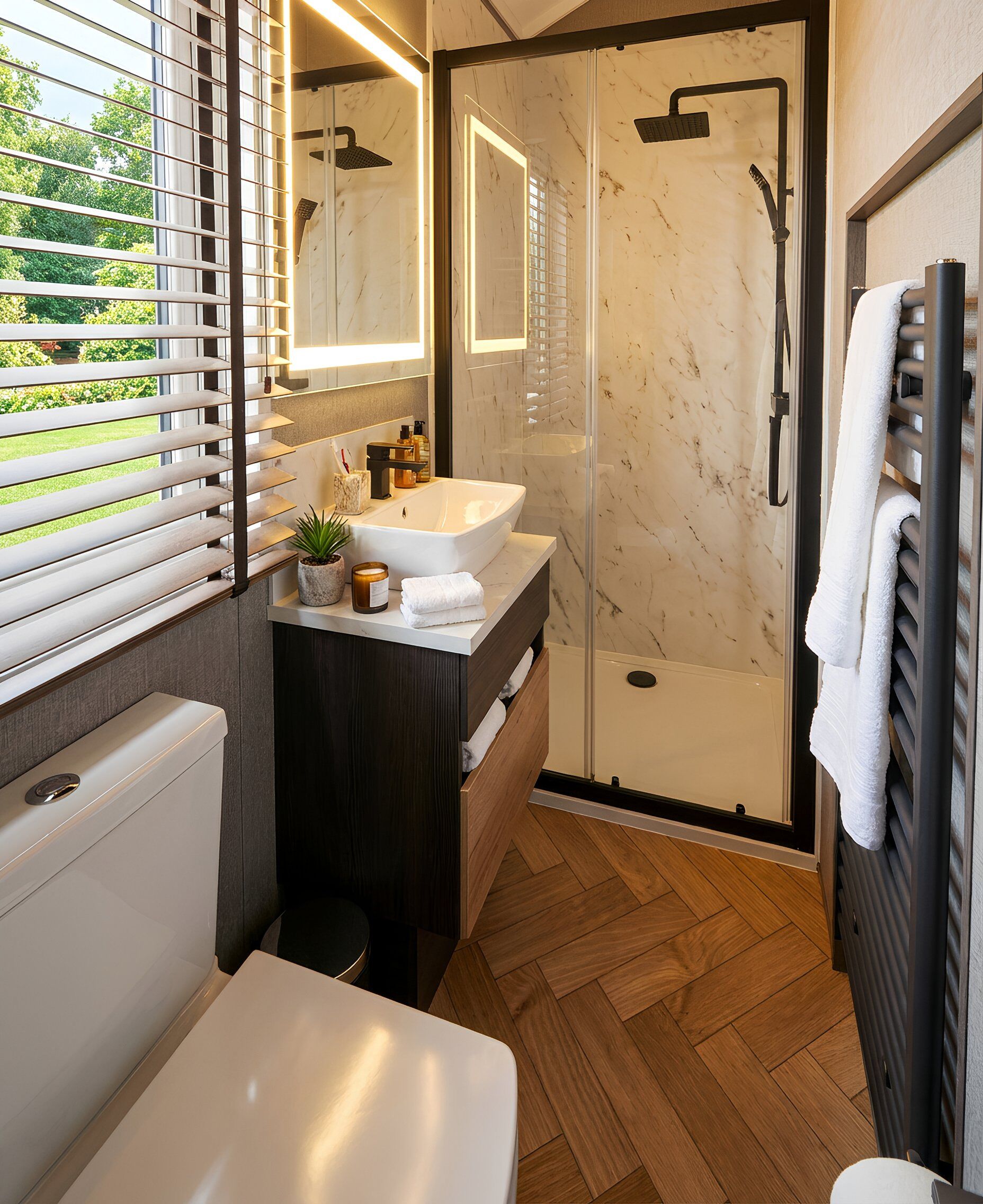 A modern bathroom with a large sink, a glass shower enclosure, and a toilet.