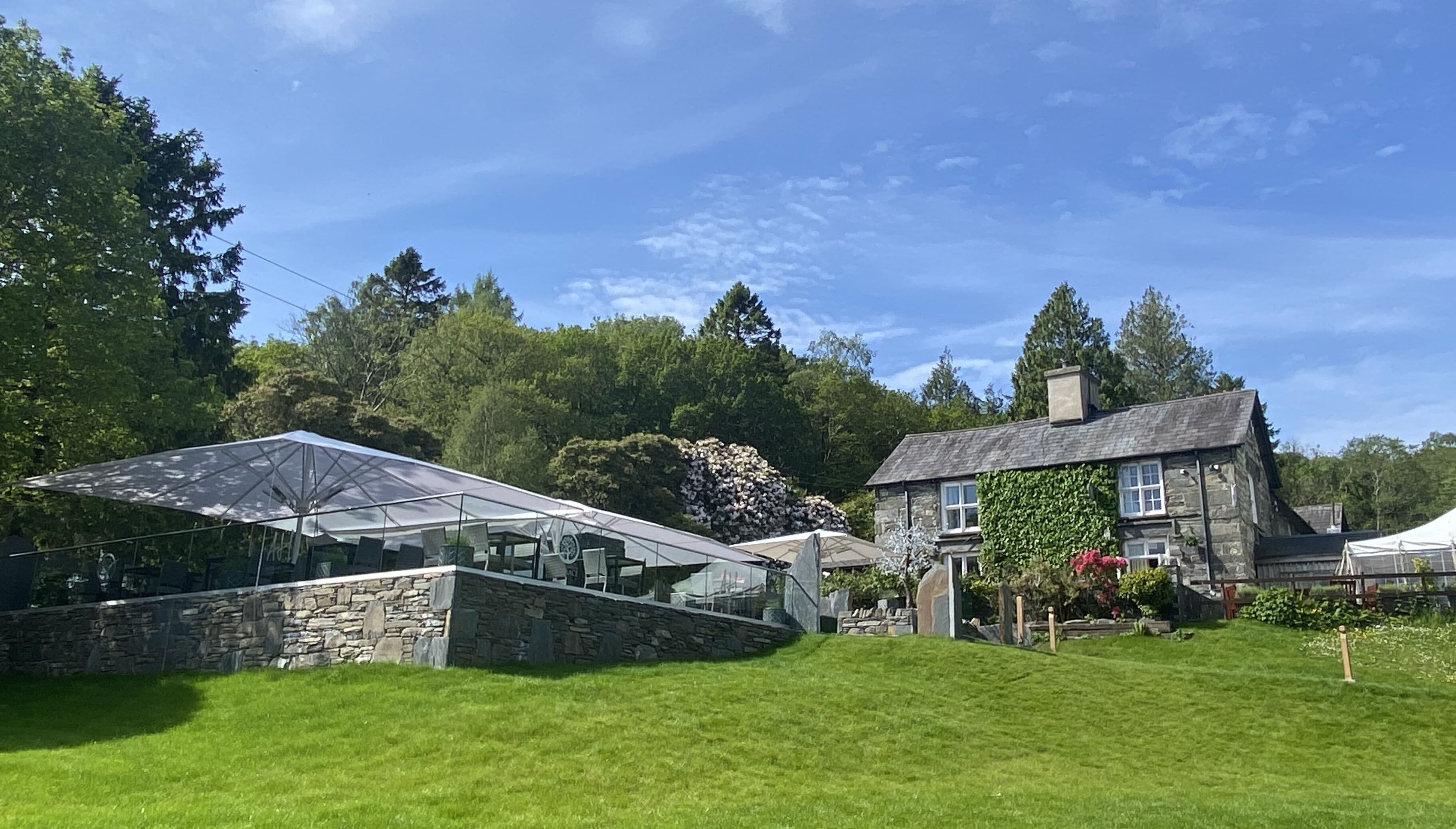 Et hus med stenvægge og et glaskonglomerat.